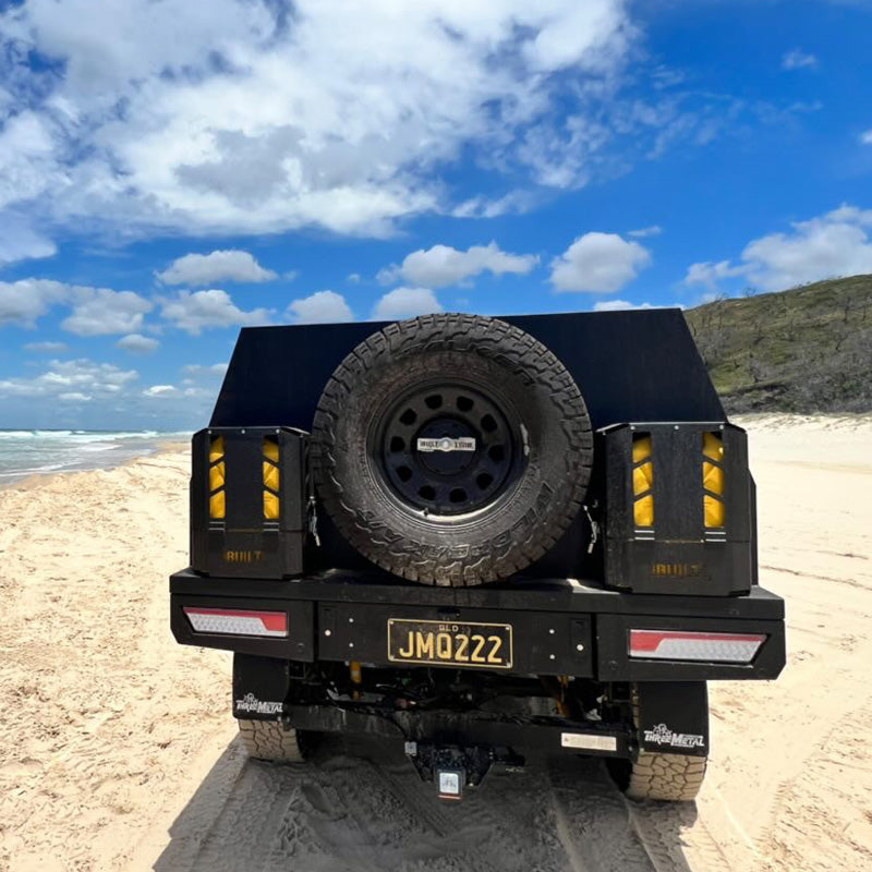 Twin locking Jerry can holders positioned either side of Canopy spare wheel mount on back of Ute canopy